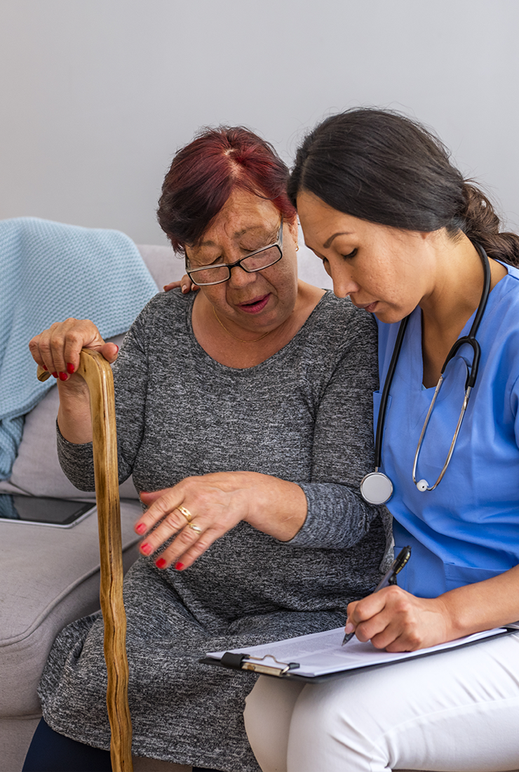 Une travailleuse de la santé offre des soins à domicile à une personne âgée au Québec. 